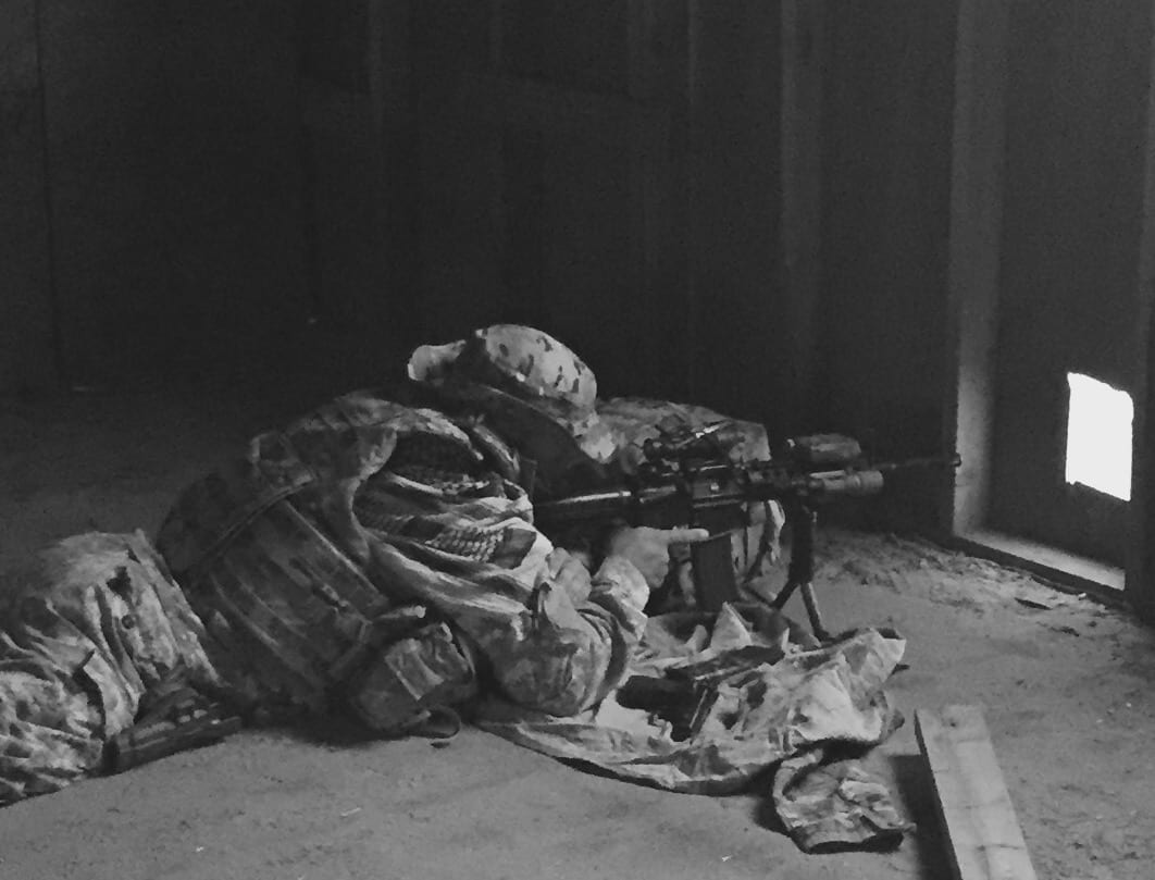 Lying on ground aiming with sniper rifle